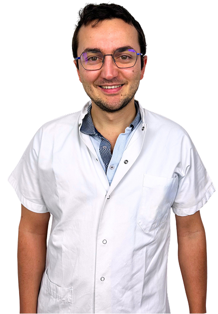 Portrait d’un médecin en tenue blanche, souriant, sur fond neutre.