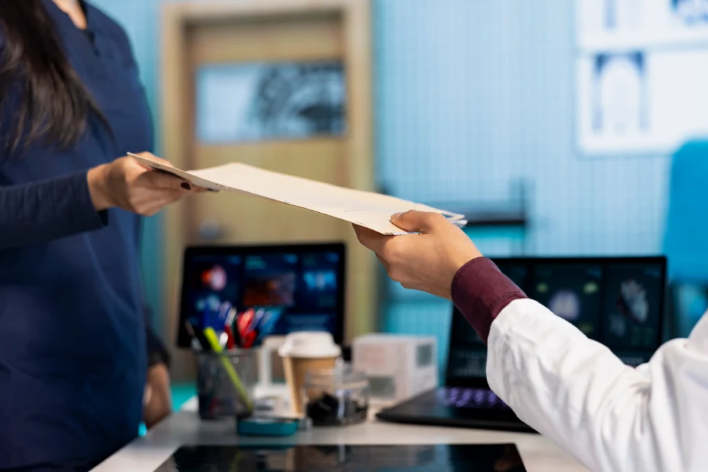 Un médecin tend un document à une patiente lors d’une consultation.
