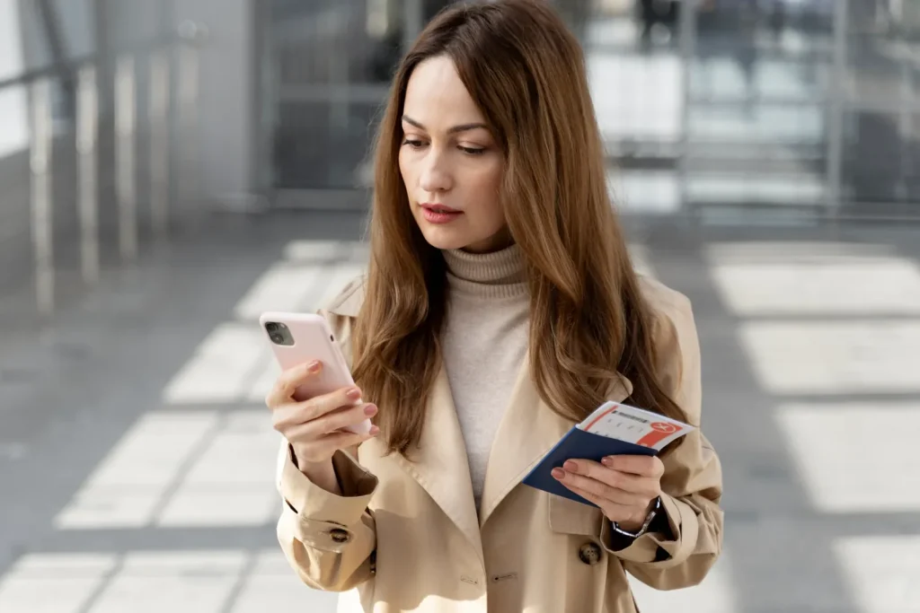 Médecin étranger consultant son téléphone et son passeport, pour choisir entre la Suisse et la France pour exercer